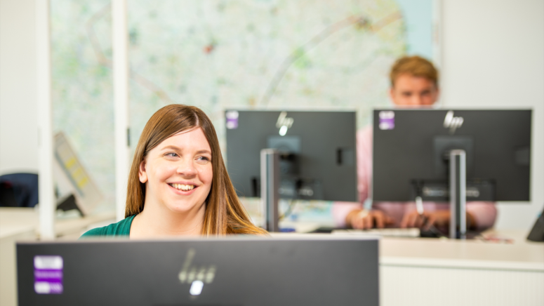 RO smiling at desk